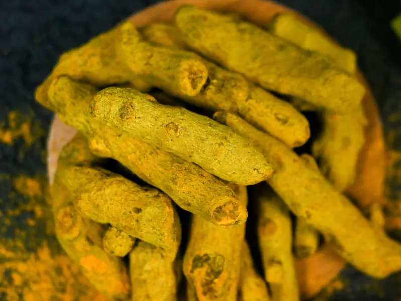 Turmeric rhizomes on a wooden plate (representative image)